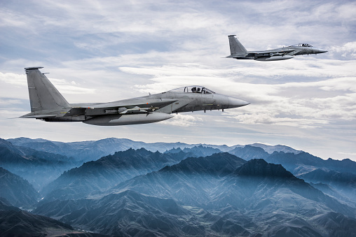 F-15 Eagle fighter jets flying above mountains
