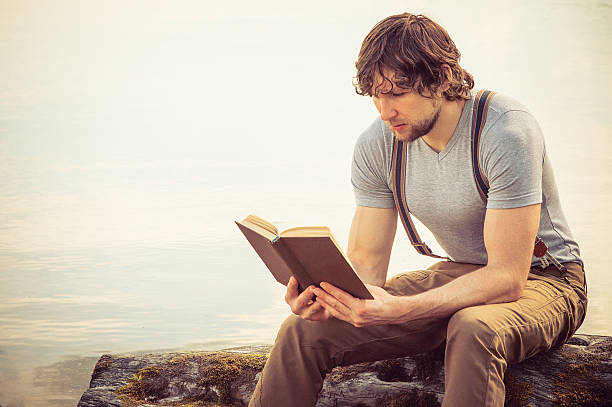 istock Young Man reading book outdoor Summer vacations Lifestyle 501295033