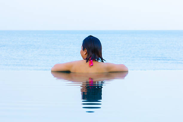 istock Woman relaxing infinity swimming pool 501295093