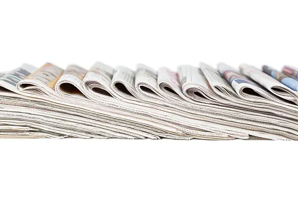 Assortment of folded newspapers isolated on white