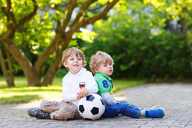 istock Two little fan boys at public viewing of football game 501295607