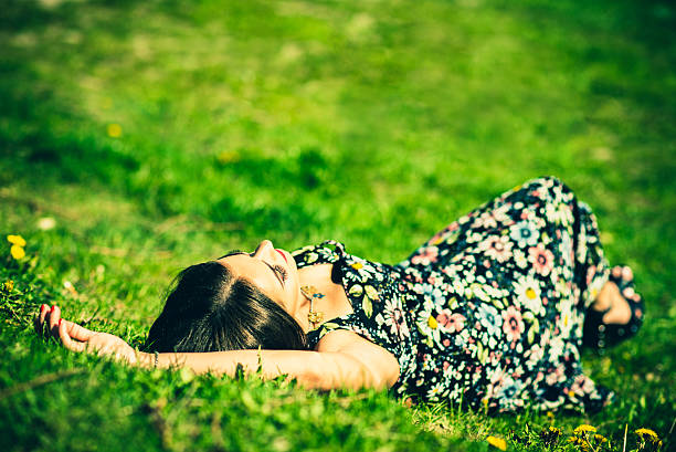 istock Pretty brunette woman relaxing on te grass in the park 501295904