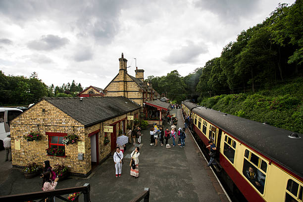 People waiting for Lakeside and Haverthwaite Railway train. Haverthwaite, England - June 14, 2014 - Group of tourists waiting at Haverthwaite Station, part of Lakeside and Haverthwaite Railway , a steam railway located in the picturesque Leven Valley. grasmere stock pictures, royalty-free photos & images