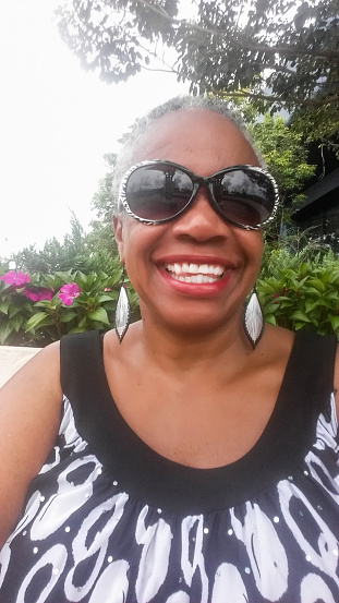 Selfie Series - Selfie of an African American woman smiling in Sunglasses outside.