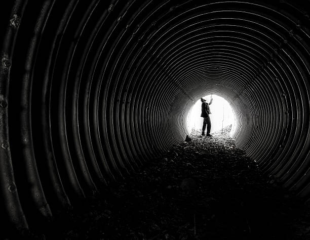 istock man in industrial tube cave looking at sky concept 501297464