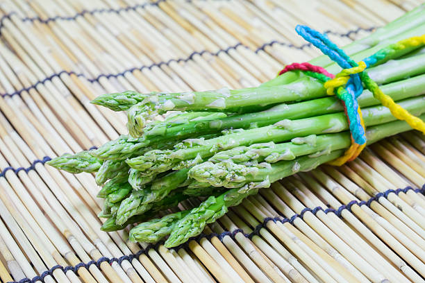 istock Delicious fresh green asparagus on bamboo mat 501297795