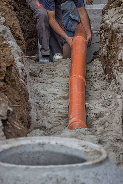 istock Workers laying PVC pipes at the ditch bottom 2 501299063
