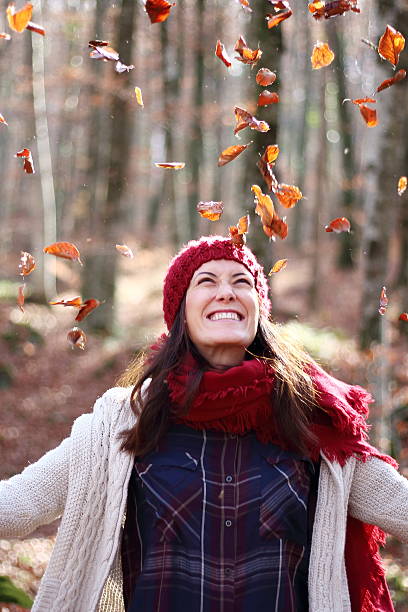 istock Young beautiful woman plays with beech leaves in the forest 501328982