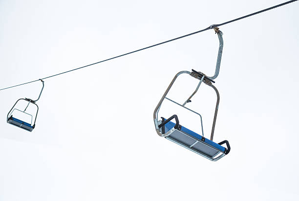 istock Ski lift chairs on bright winter day 501337145