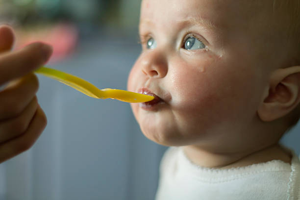 istock Yellow Spoon by the Baby Mouth 501337164