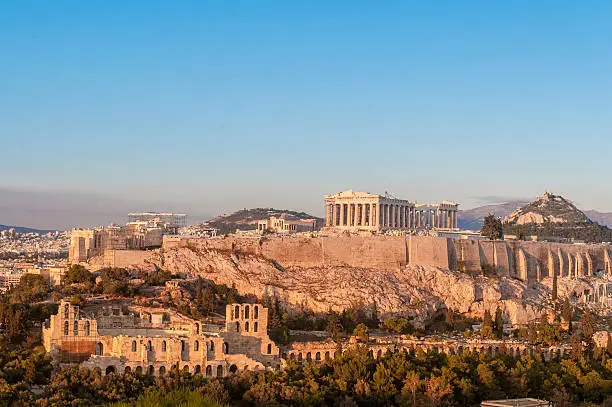 Acropolis Hill, Parthenon,Theater of Herodes Atticus and Lycabettus (Lykavittus) Hill. Clear blue sky. Afternoon glow.