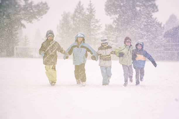 istock Five children running in a snow storm at school 501340004
