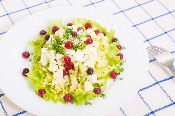 dietary salad from avocado, eggs, and cowberry on blue tablecloth
