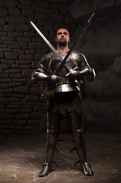 istock Medieval Knight posing with two swords on in a dark 501341171
