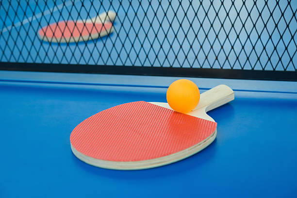 istock pingpong rackets and ball and net on blue pingpong table 501341592