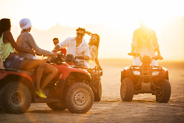 istock Happy friends having fun on quad bikes at sunset. 501355008
