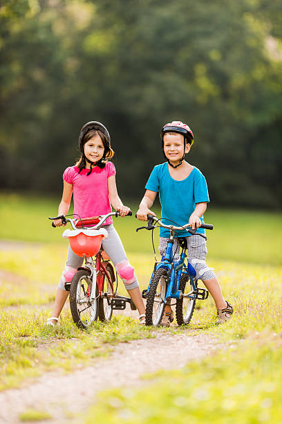 istock Two smiling children cycling in the park during springtime. 501355244