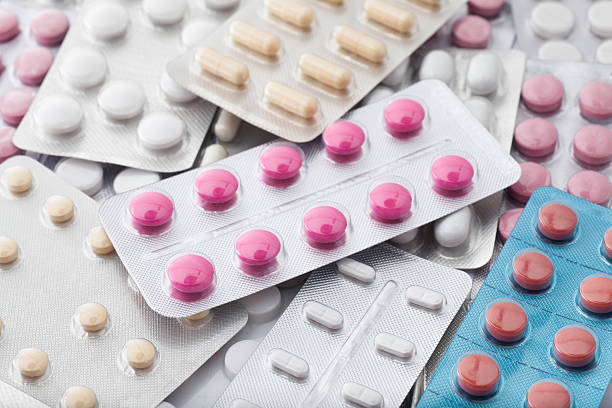 груду таблетки в блистерной упаковки фоне - vitamin pill excess pill capsule стоковые фото и изображения
