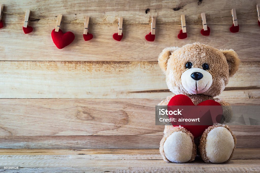 Teddy bear holding a heart-shaped pillow Heart Shape Stock Photo