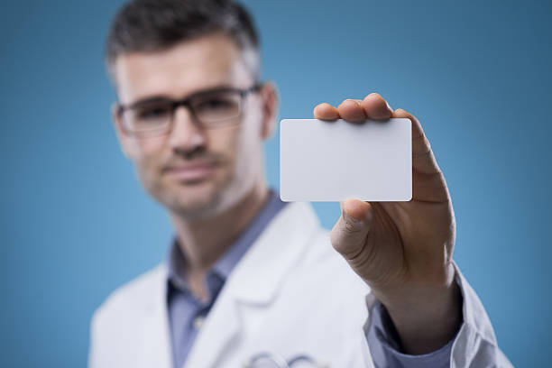 médico sorridente com cartão de negócios - glasses holding business card imagens e fotografias de stock