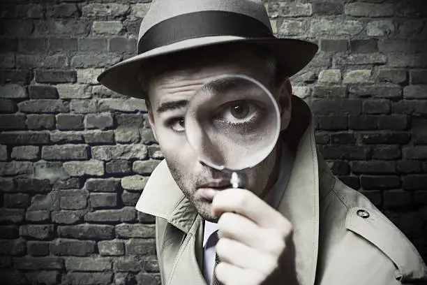 Photo of Vintage detective looking through a magnifier