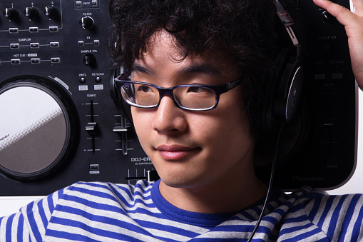 Korean dj holding turntable on shoulders looking sideways