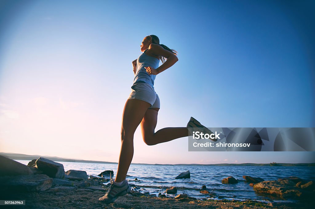 Girl running Photo of young woman running on the beach at sunrise Active Lifestyle Stock Photo