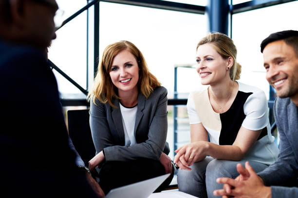 istock Female executive smiling at camera sitting with colleagues 501364134