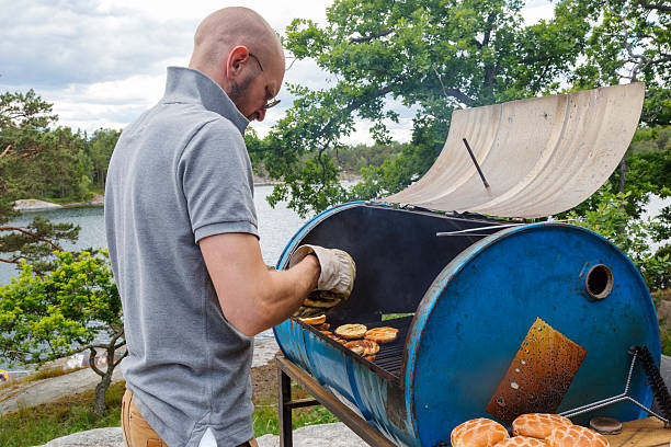 istock Man heating hamburger bread on home made grill. 501364419