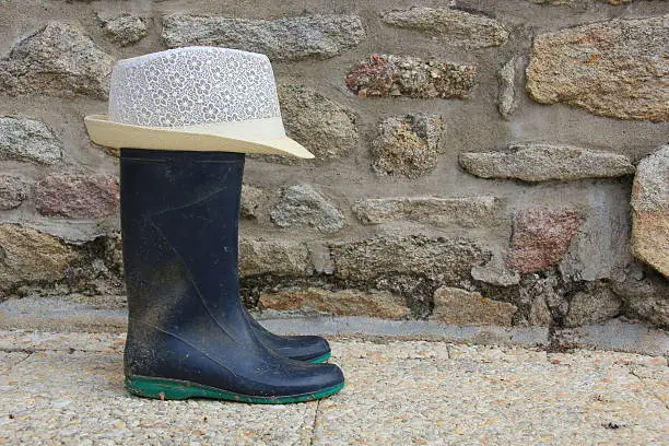 rubberboots with hat in front of the farmhouse