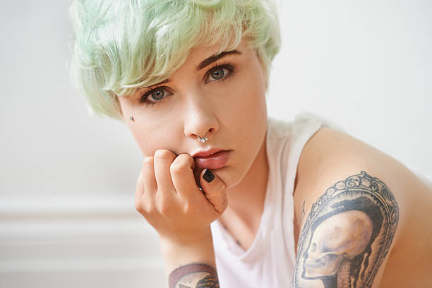 Portrait of a young woman with tattoos and pink hair photographed in London