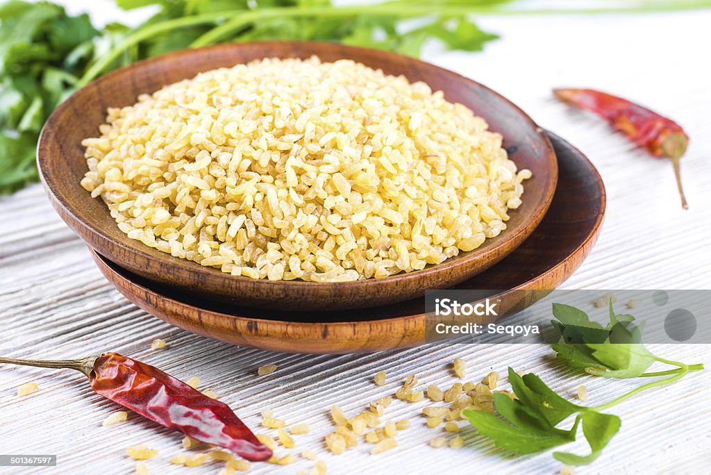 Bulgur in a wooden plate Bulgur in a wooden plate with red pepper Bulgur Wheat Stock Photo