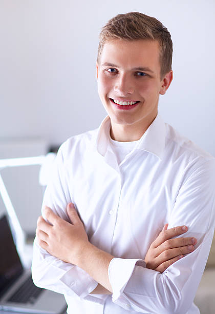 istock Young businessman with folded arms standing  in the office 501367864