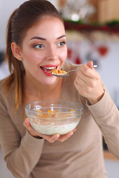 istock Smiling attractive woman having breakfast in kitchen interior 501384802