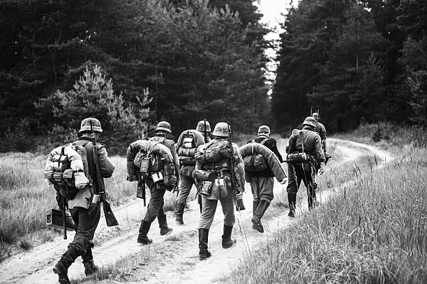 Unidentified re-enactors dressed as World War II German soldiers Svetlogorsk, Belarus - June 20, 2014: Unidentified re-enactors dressed as World War II German soldiers walks  on forest road. Black and white photography world war ii photos stock pictures, royalty-free photos & images