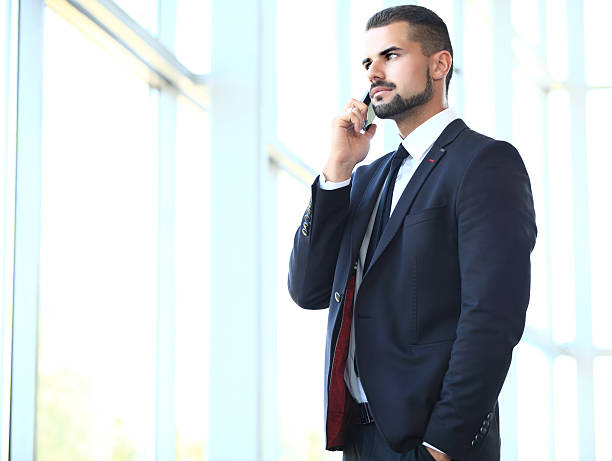 istock Cheerful smiling men office worker talking on mobile phone 501386088