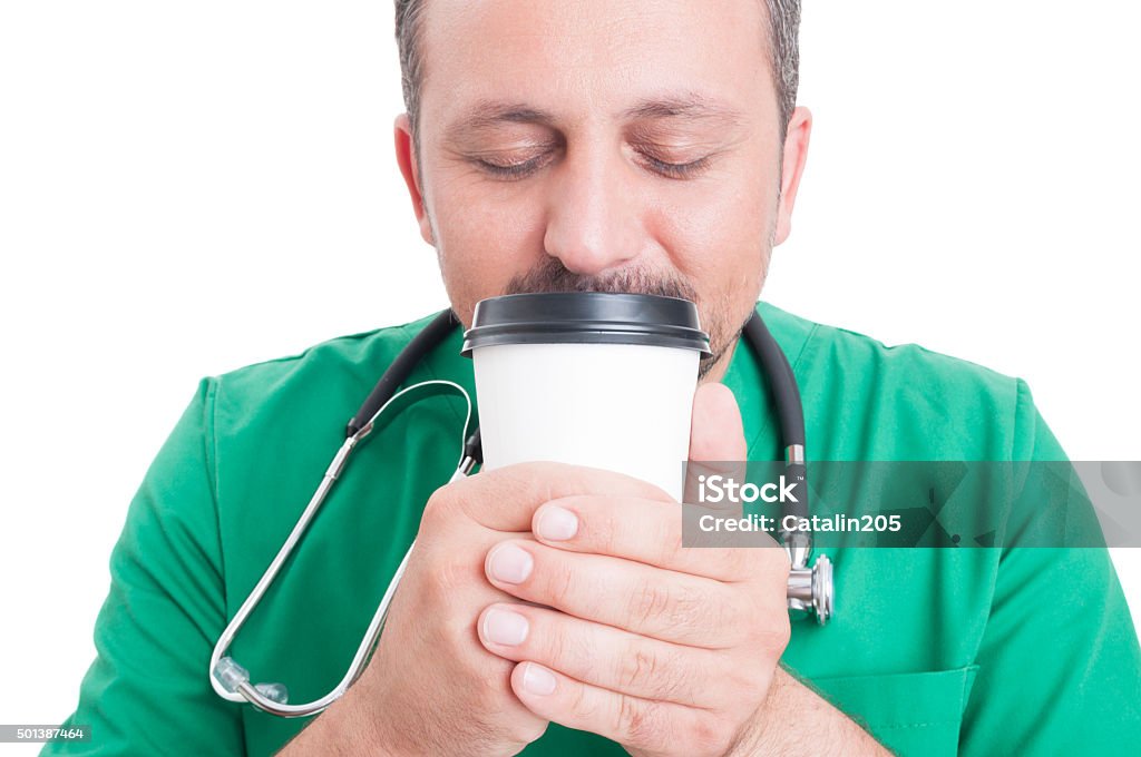 Male doctor smelling fresh coffee Male doctor smelling fresh coffee from a disposable cup in his break Coffee - Drink Stock Photo