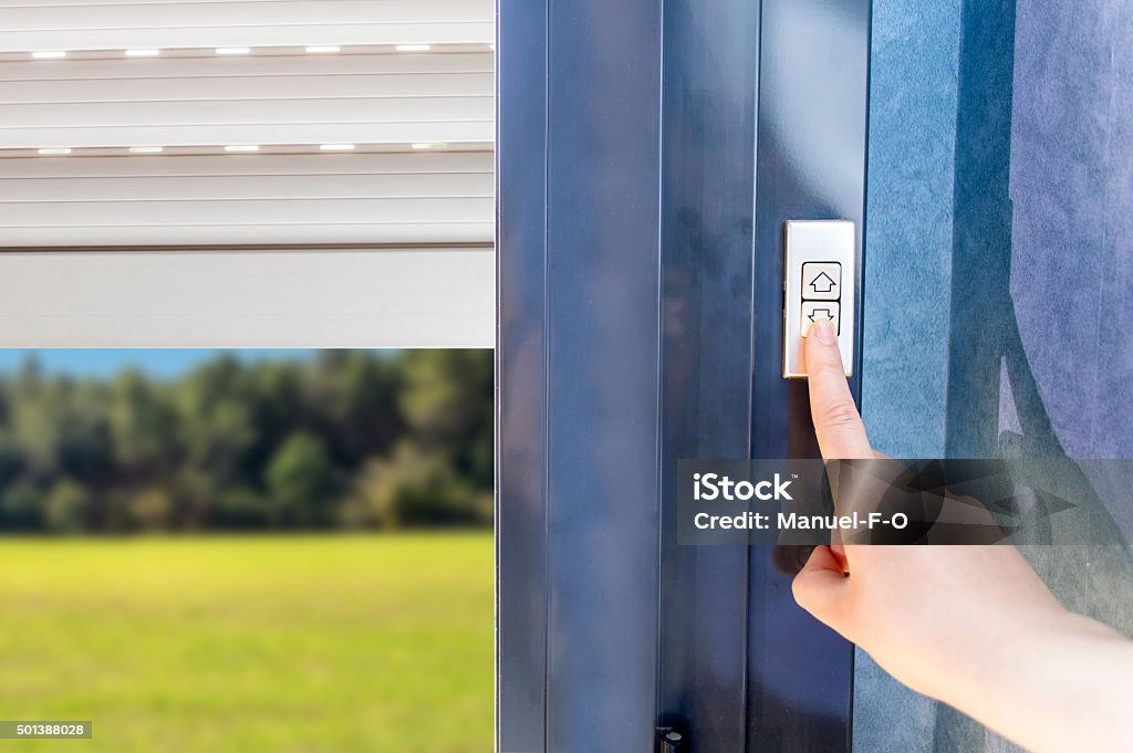 electric shutters Woman lifting electric shutters in house Shutter Stock Photo