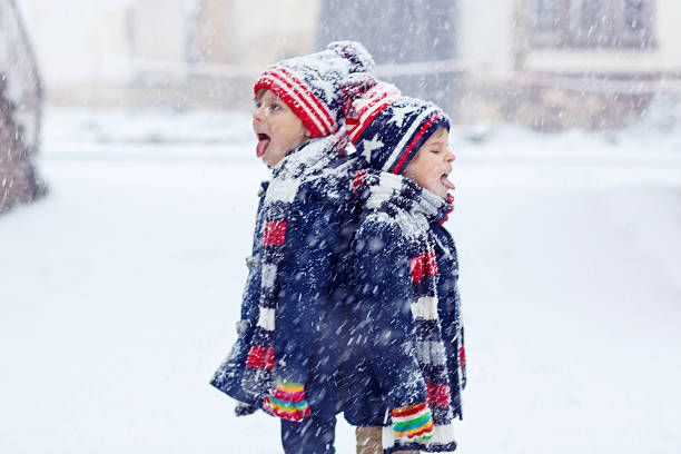 istock Two happy little boys having fun with snow in winter 501391190