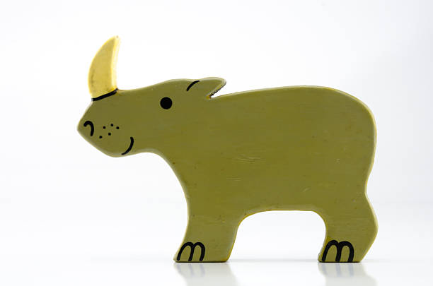A wooden rhinoceros toy against a white background