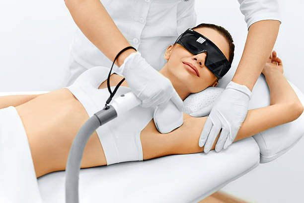 Body Care. Laser Hair Removal. Epilation Treatment. Smooth Skin. Body Care. Underarm Laser Hair Removal. Beautician Removing Hair Of Young Woman's Armpit. Laser Epilation Treatment In Cosmetic Beauty Clinic. Hairless Smooth And Soft Skin. Health And Beauty Concept. hair removal photos stock pictures, royalty-free photos & images