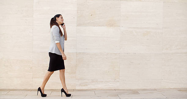 istock Woman walking along a sidewalk 501422036