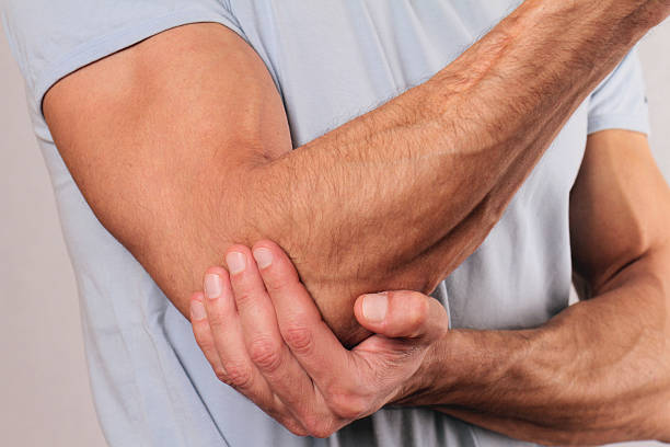 homme avec une douleur au coude. concept de soulager les douleurs - human hand science human muscle muscular build photos et images de collection