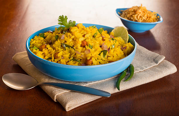 Poha - Popular Indian Breakfast Poha is a widely eaten breakfast preparation, enjoyed all over India. It is basically flattened rice flakes tempered with Onions, Mustard seeds, Green Chillies, Peanuts, Curry leaves. It is often served with a slice of lime and sev ( savoury noodle like topping). mustard fruits stock pictures, royalty-free photos & images