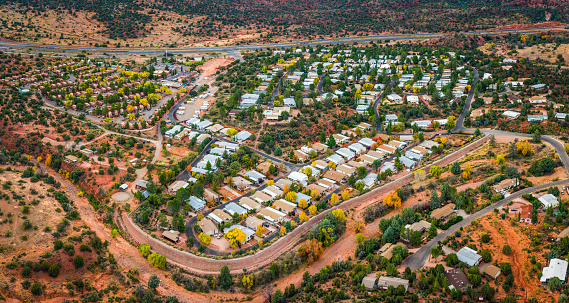 Aerial photograph of suburban homes arranged neatly around curving roads surrounded by red desert scrubland. ProPhoto RGB profile for maximum color fidelity and gamut.