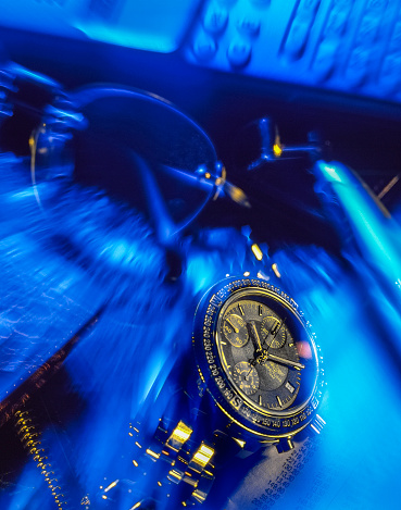 Leiden, The Netherlands - June 1, 2015: luxury Breitling Cronoliner wristwatch in futuristic setting. Business items, like phone,glasses and pencil are blue lit, and with a zoom effect. The watch is sharp.