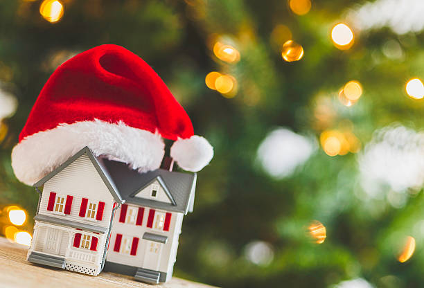 istock House with Santa hat under Christmas tree. Relocation concept. 501433222