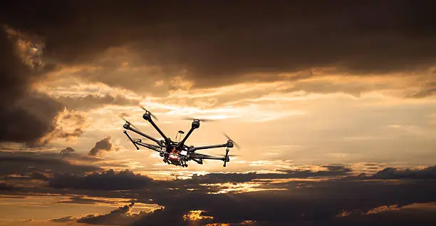 Flying copter with their gear on the background of a beautiful sunset.