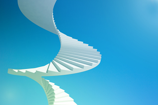 Spiral staircase going up to the sky, moving up to success: blue sky, shining sun. Motivating to new beginnings and achievements. Copy space.
