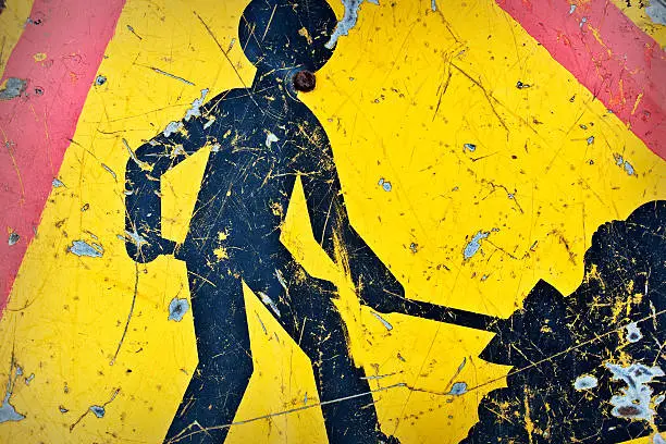 Close-up of an old yellow french road work sign